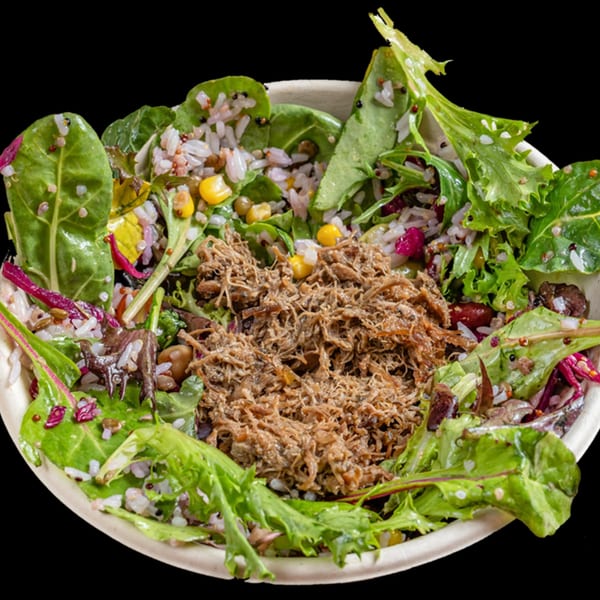A healthy bowl from Bowls N Go with shredded meat, mixed greens, rice, corn, and beans.