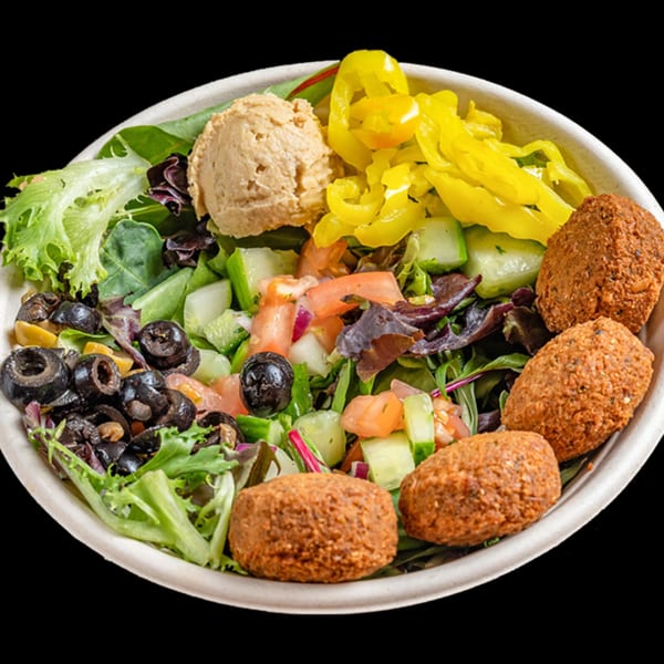 A healthy Bowls N Go falafel bowl with hummus, olives, peppers, and fresh greens.