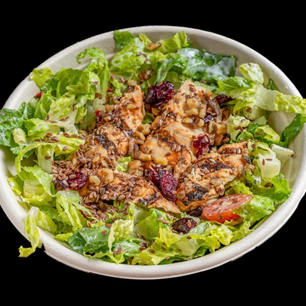 Healthy Bowls N Go salad with grilled chicken, cranberries, nuts, and flax seeds.