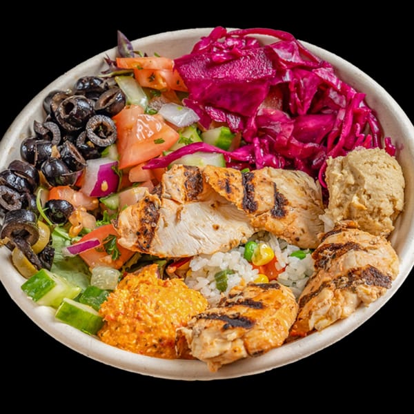 A healthy Bowls N Go bowl with grilled chicken, rice, black olives, red cabbage, and hummus.